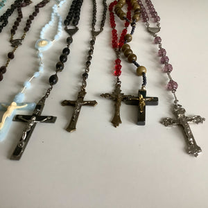 Vintage French rosaries, Gray Barn Eclectic Finds online vintage store, group of blue plastic, black bead, red crystal, round stone, and purple rosaries shot lengthwise