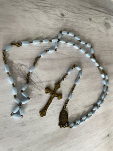 Group of vintage rosaries and chaplets on white wood background, Gray Barn Eclectic Finds online vintage store, pale blue opaque oblong beads with antique brass findings