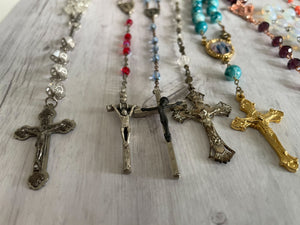 Group of vintage rosaries and chaplets on white wood background, Gray Barn Eclectic Finds online vintage store, photographed along their length