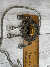 Load image into Gallery viewer, vintage silver plate boho filigree necklace with 20&quot; long chain; pendant is oval with dangling teardrops, and made from twisted wire into scrolls and whirls; against ruler